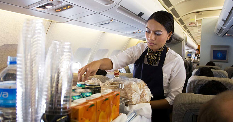 flight attendant serving food and beverages to passengers 
