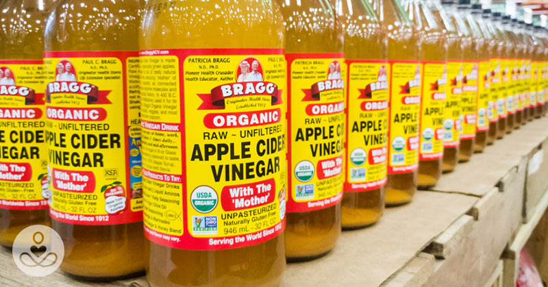 A grocery store shelf stocked with apple cider vinegar