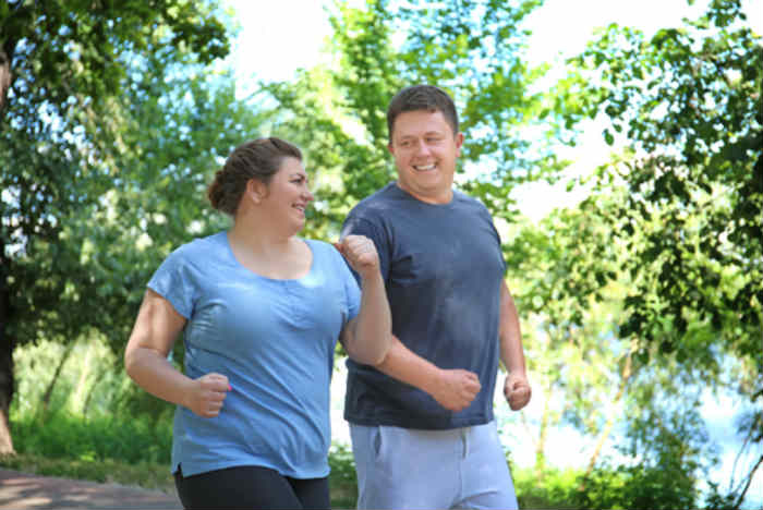 An overweight man and woman exercising