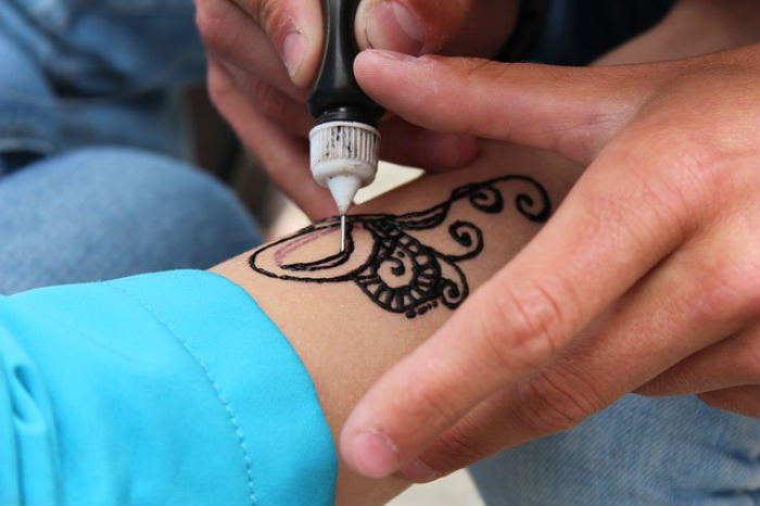 Person getting a Black Henna Tattoo on their arm
