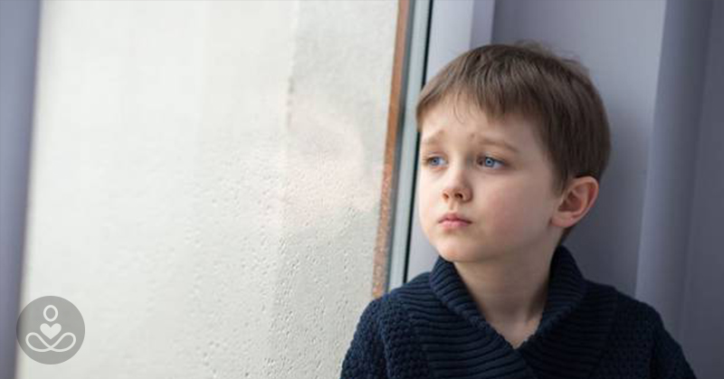 Short hair young child looking out a window