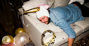 drunk man passed out on a white leather couch