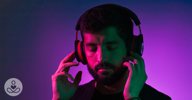 man listening to woman on headphones with purple background