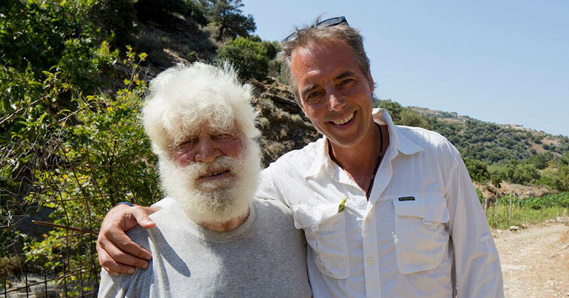 older greek man with white hair and white beard with younger man
