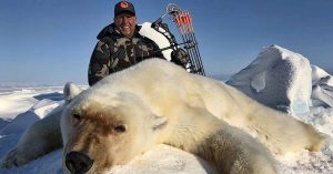 Expert Warns Trophy Hunting Could Push Polar Bears To Extinction dead polar bear with hunter