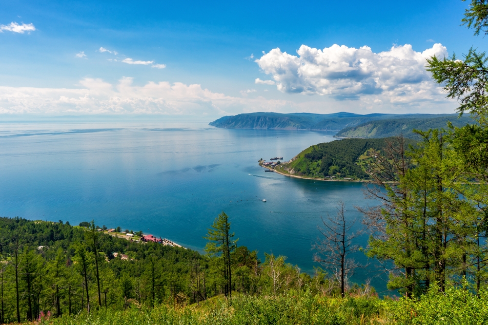 Beautiful summer panoramic landscape with view from hill to lake Baikal shore and Angara source. Chersky stone in Listvyanka village at Baikal lake coast. Amazing siberian nature. Siberia, Russia