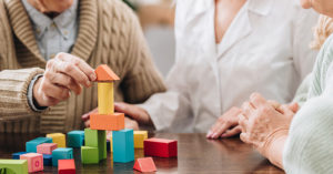 older people playing with wooden toys