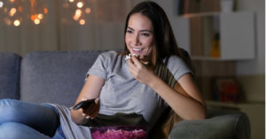 woman on couch eating popcorn