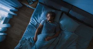 The science behind why your body jerks when you fall asleep man sleeping in bed