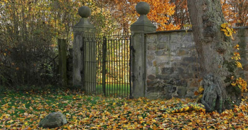 woman hiding in photo of old stone gate