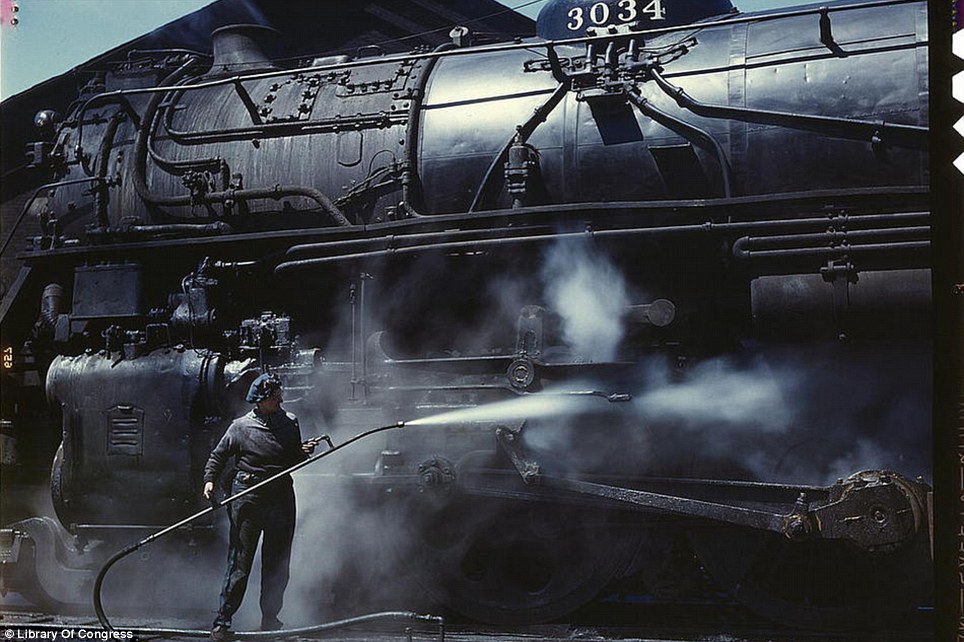 April 1943: Mrs. Viola Sievers steam-cleaning a huge ‘H’ class locomotive in Clinton, Iowa