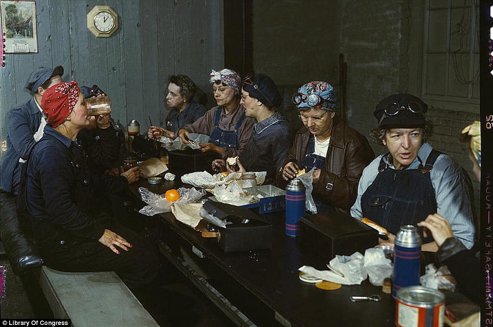 April 1943: Women workers in the roundhouse taking a lunch break in at the Chicago and Northwest Railway Company in Clinton, Iowa.