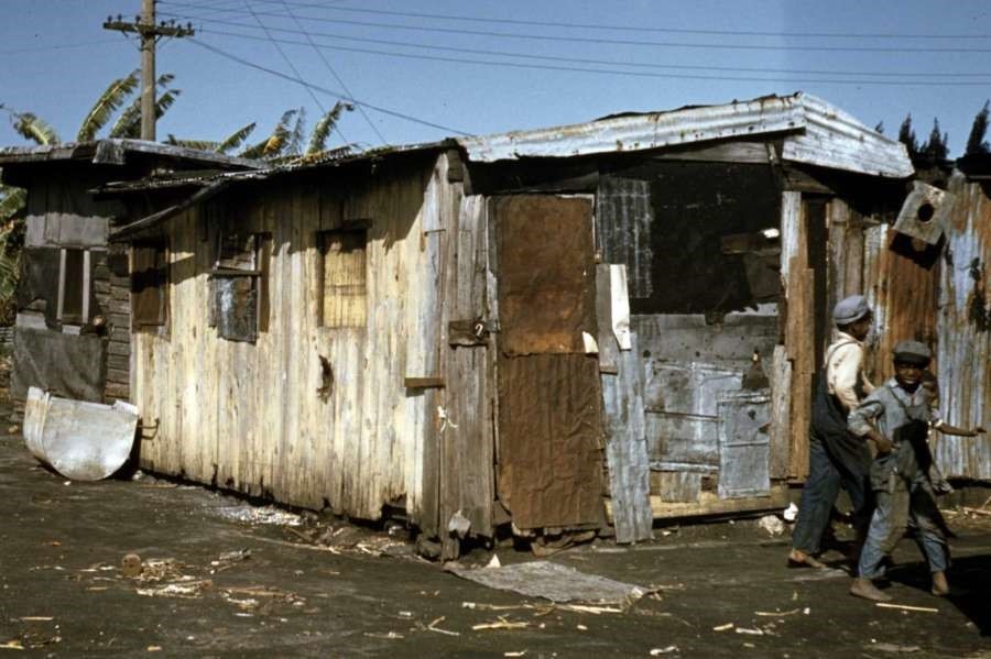 Black migratory workers outside shacks in 1941