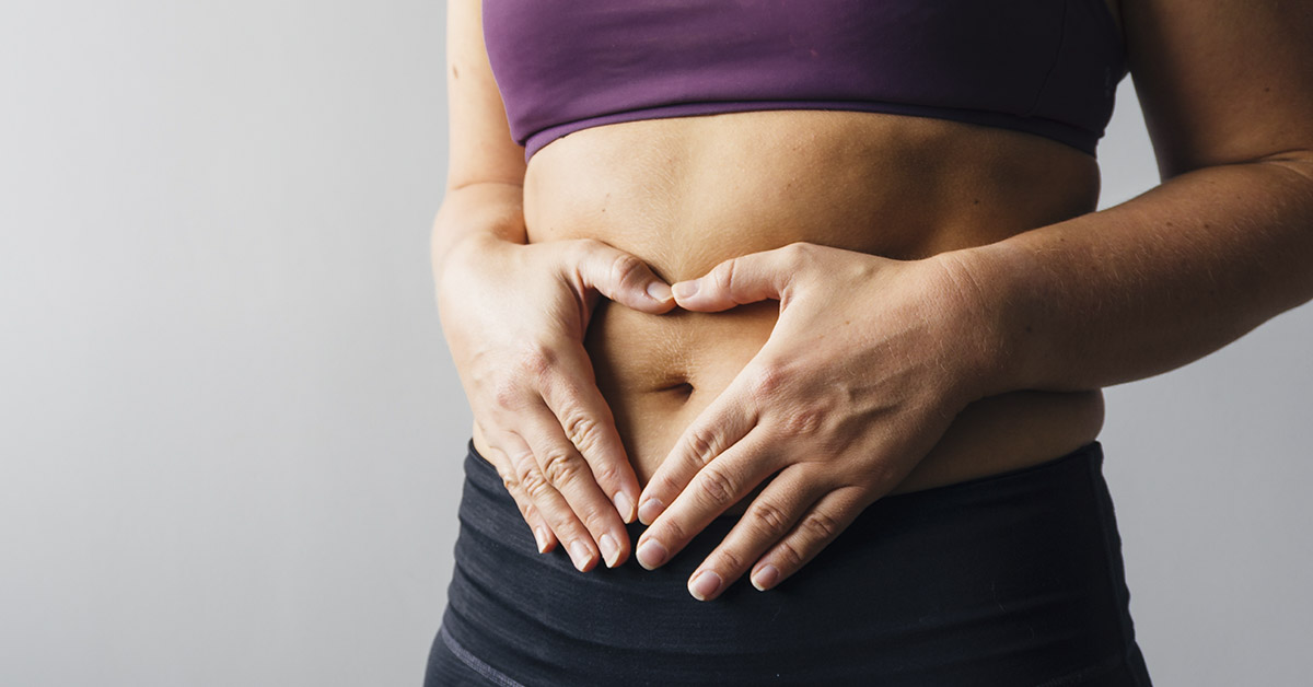 woman holding gut due to bloating
