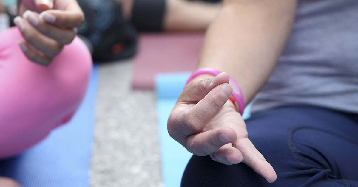 close up of hands of children meditating in lotus pose