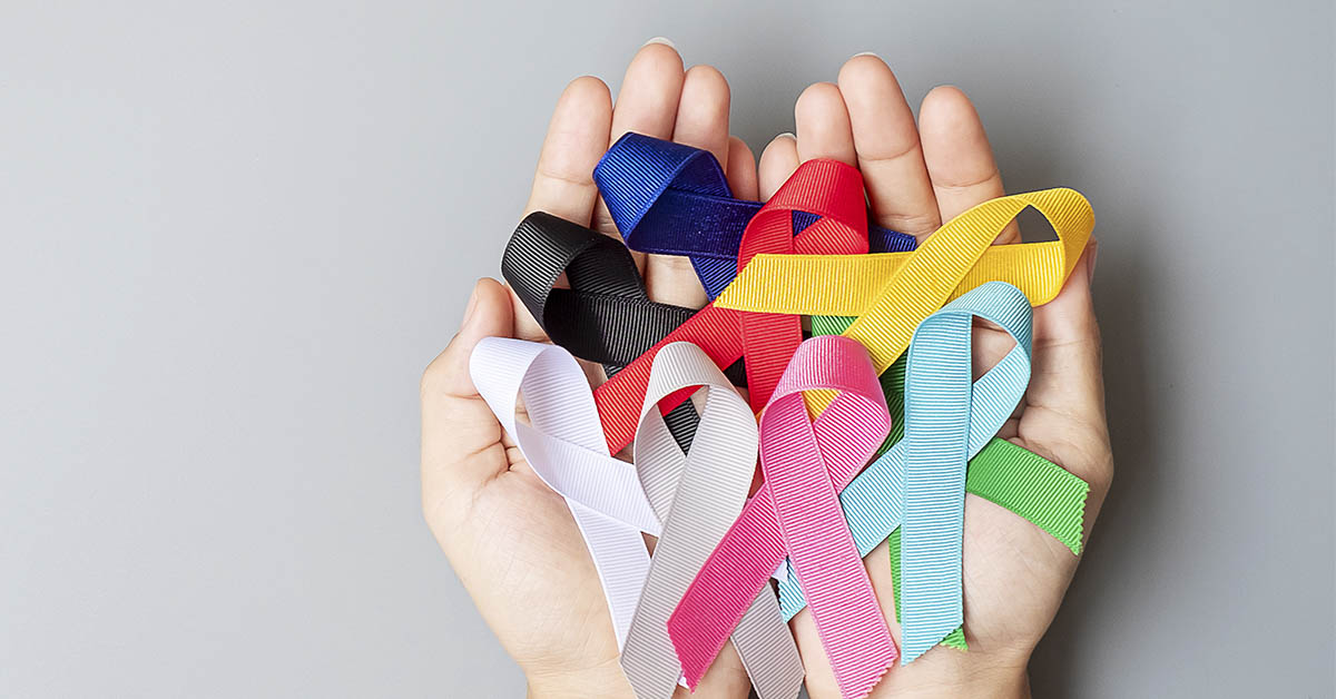 hands holding various cancer ribbons