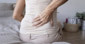 14 Self-Help Tips for Sciatica That Truly Work person holding back due to sciatic pain