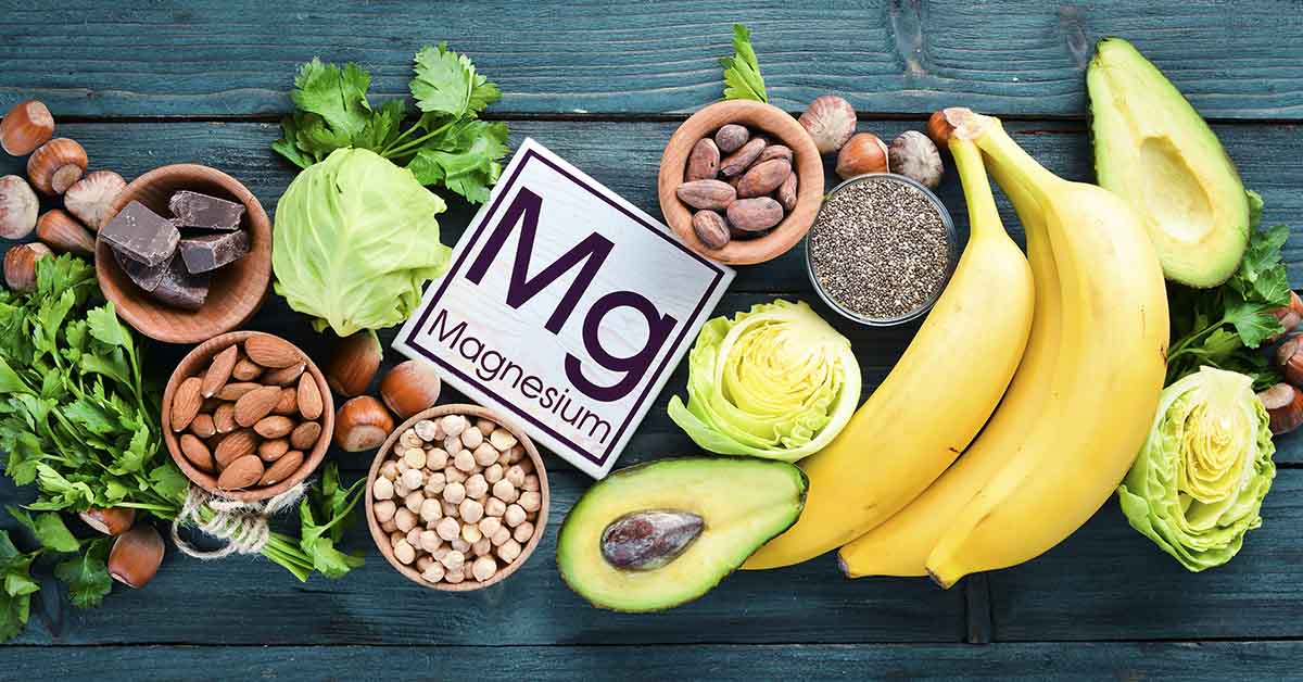 an array of foods with with a sign with "Mg" on it as short form for Magnesium