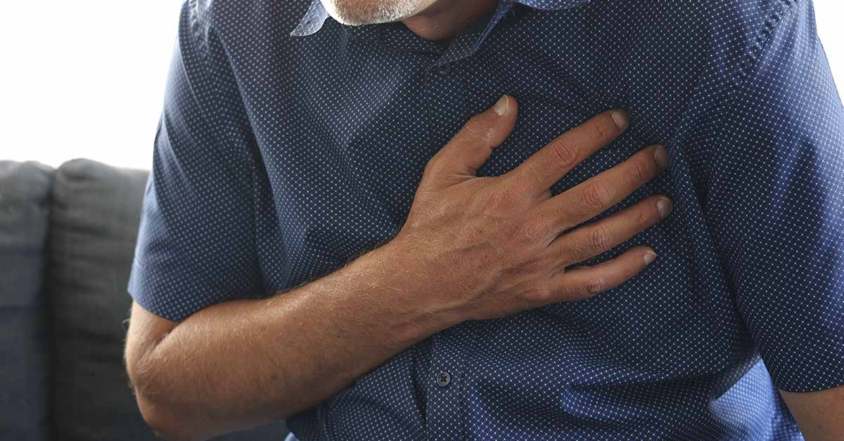 man holding chest due to heart attack