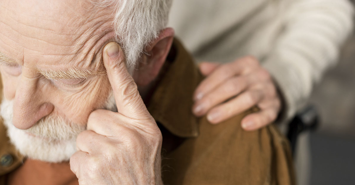 hand placed on shoulder of man with dementia