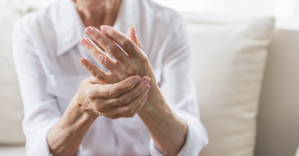 woman holding hand due to arthritis pain