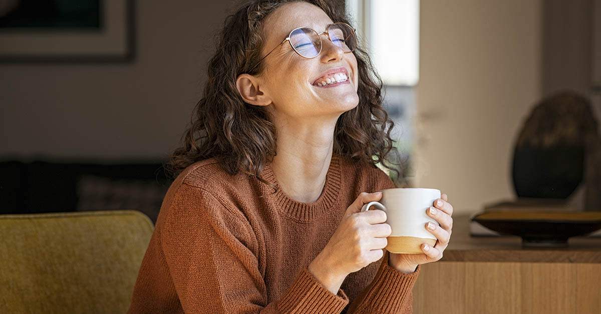 smiling woman drinking tea or coffee