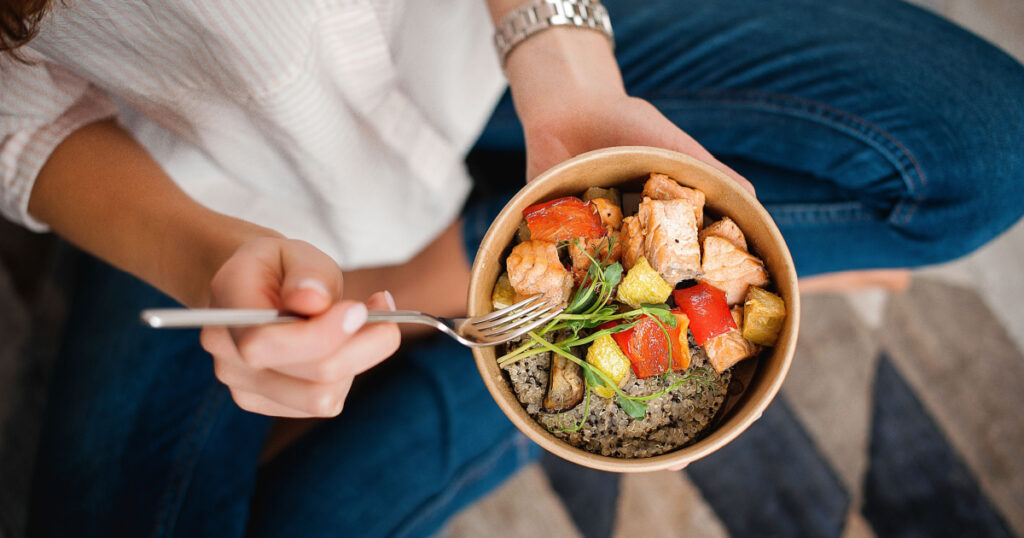 woman holding bowl of healthy food