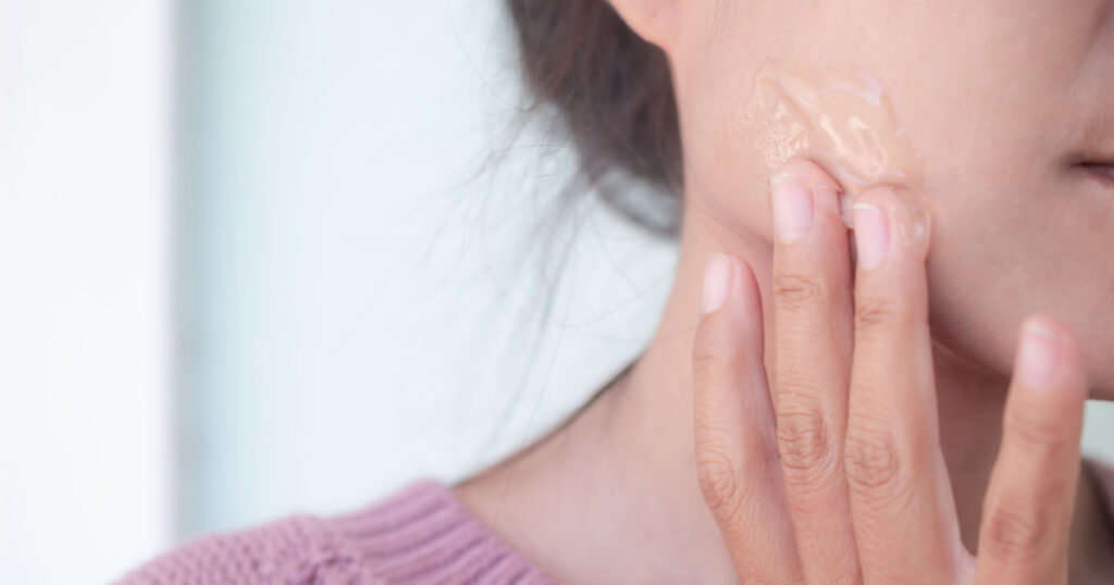 woman applying aloe vera to face