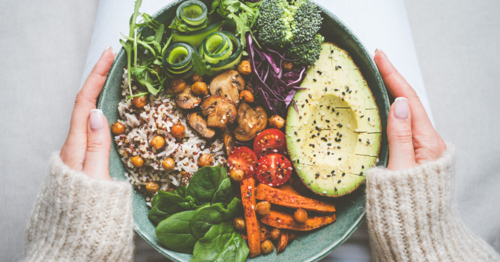 Woman holding plate with vegan or vegetarian food. Healthy plant based diet. Healthy dinner or lunch. Buddha bowl with fresh vegetables. Healthy habits for eating