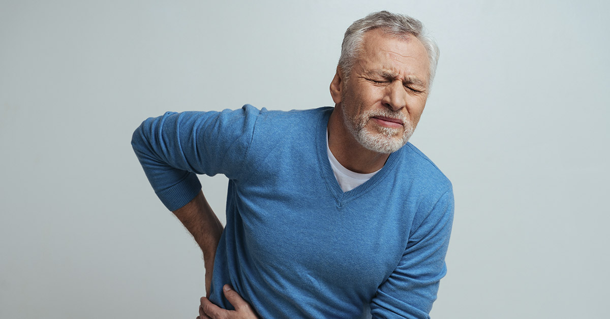 man in blue sweater with pain in kidneys
