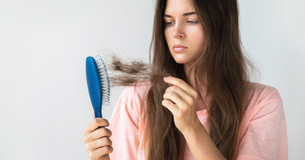 Young woman is very upset because of hair loss
