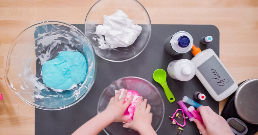 Step by step. Flat lay. Mother and daughter making colorful fluffy slime.