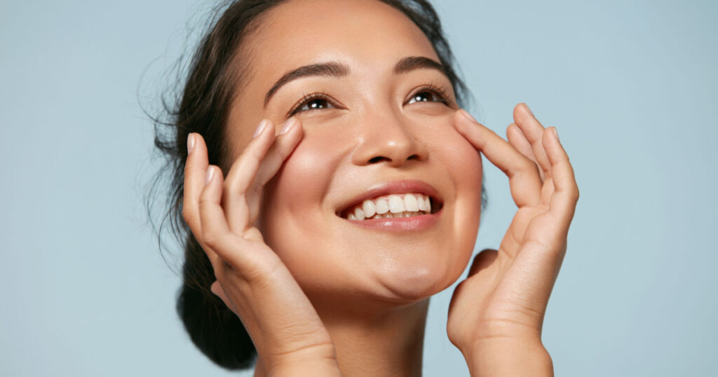 smiling asian girl with glowing hydrated skin