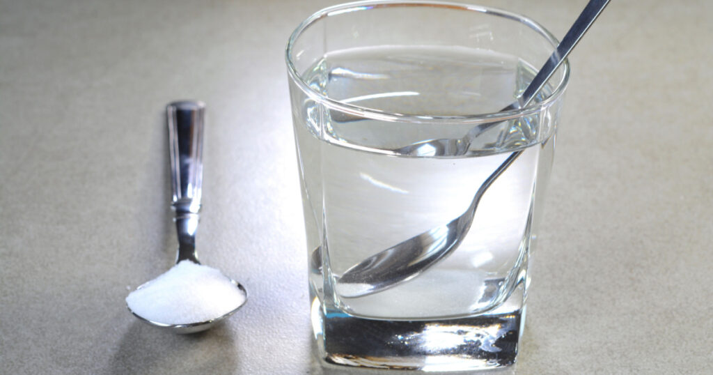 Salt water in a glass cup and salt in a teaspoon to get rid of phlegm and mucus