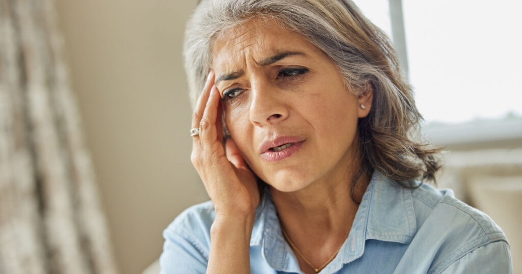 Mature Woman At Home Suffering From Headache Or Memory Loss