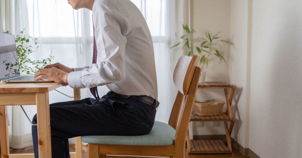 A man with a bad posture. He is a businessman who works at home.