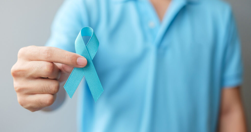 November Prostate Cancer Awareness month, Man in blue shirt with hand holding Blue Ribbon for supporting people living and illness. Healthcare, International men, Father and World cancer day concept