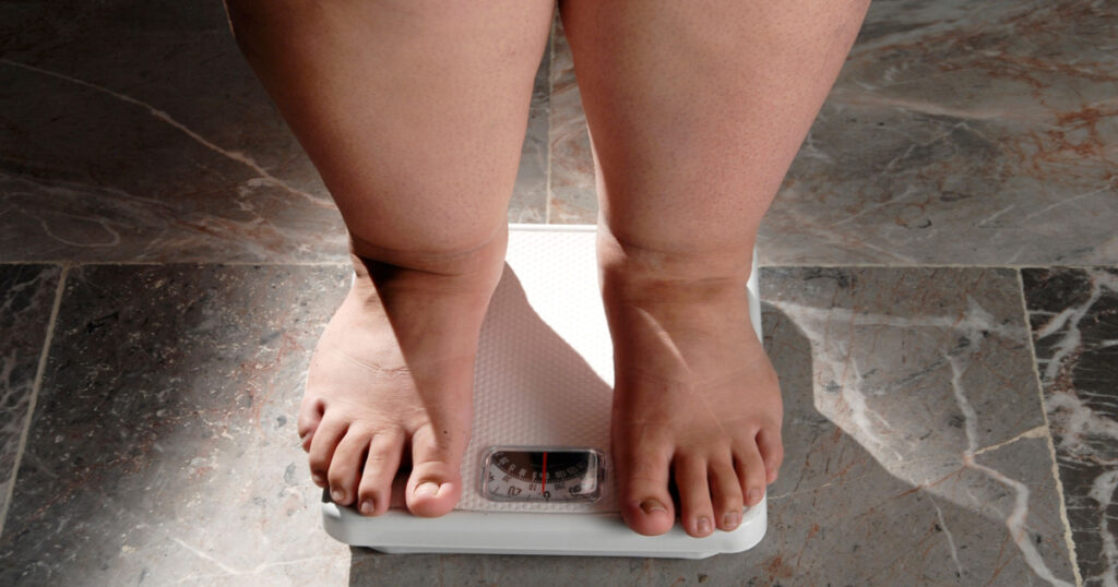 obesity and overweight, overweight woman feet on the scale, concept of obesity and bad habits