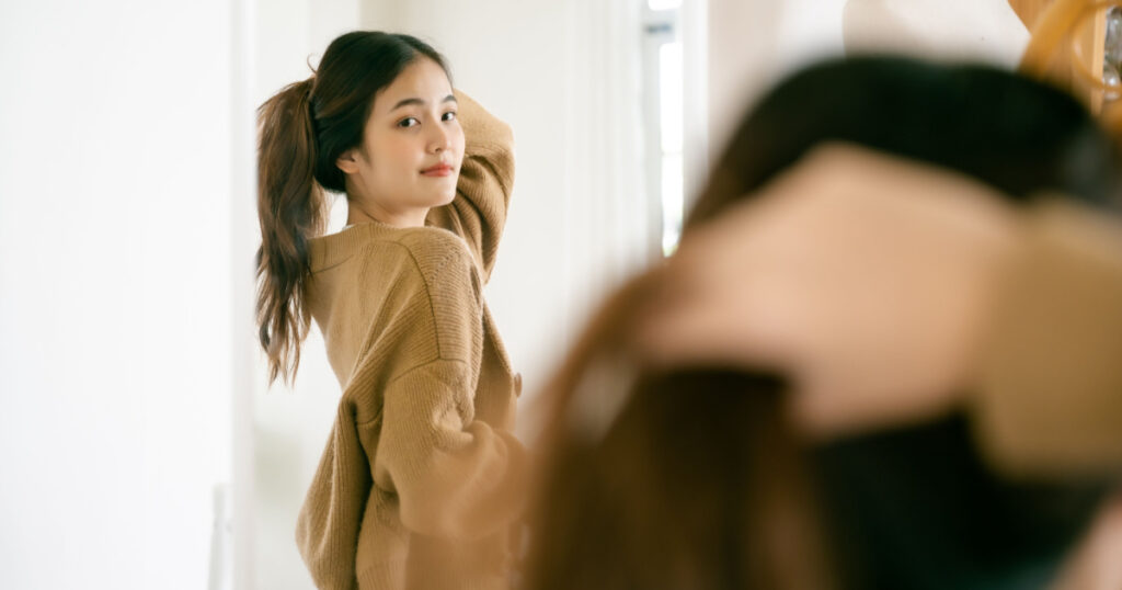 young girl looking in mirror 