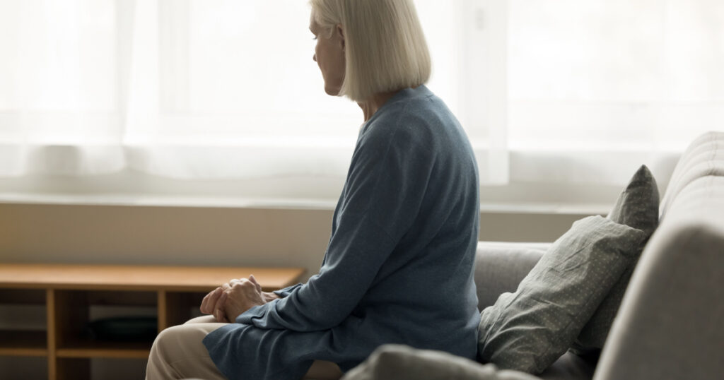 elderly retired woman sitting on sofa