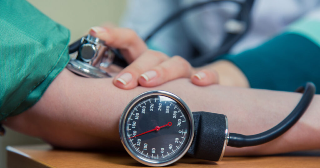 healthcare, hospital medicine concept - doctor and patient measuring blood pressure
