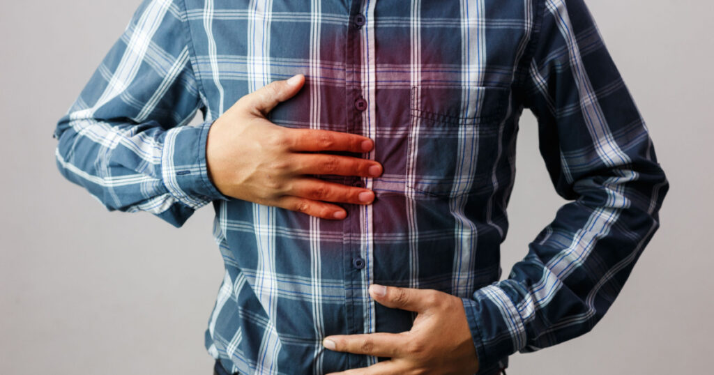 man with symptoms of burning sensation in the middle of the chest caused by acid reflux