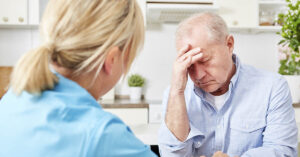 8 Useful Herbs for Memory and Brain Health man holding head, having trouble thinking. Dementia and brain health concept