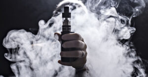 Timeline of what happens to your body when you give up vaping hand holding a electronic cigarette or vaping device. A vape cloud surrounds