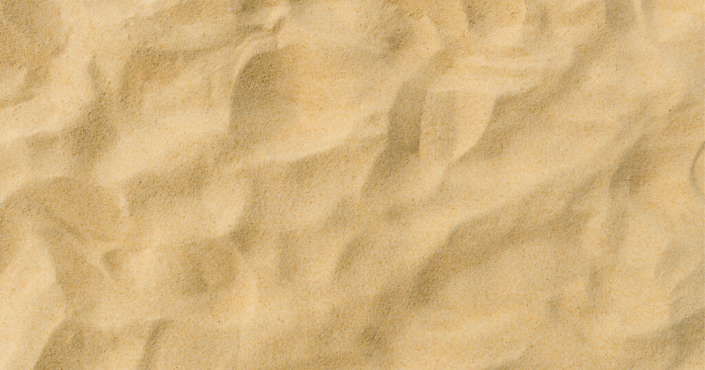 closeup of sand pattern of a beach in the summer
