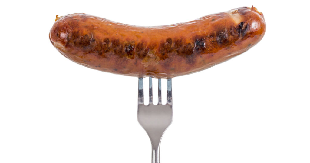 Grilled Sausage on a fork isolated on white background
