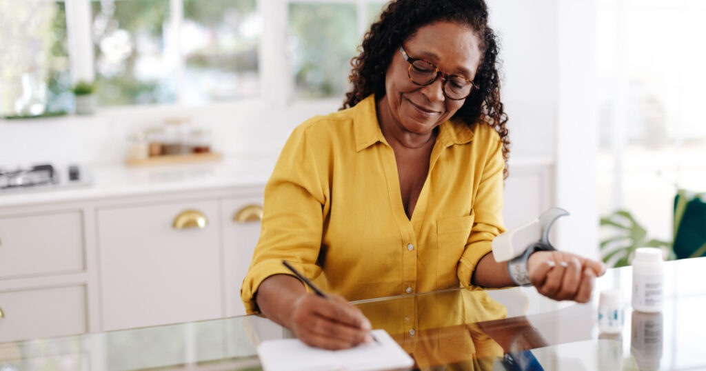 Aging woman recording and monitoring her blood pressure readings as part of her chronic disease management at home. Hypertensive woman taking the necessary steps to maintain a healthy quality of life.
