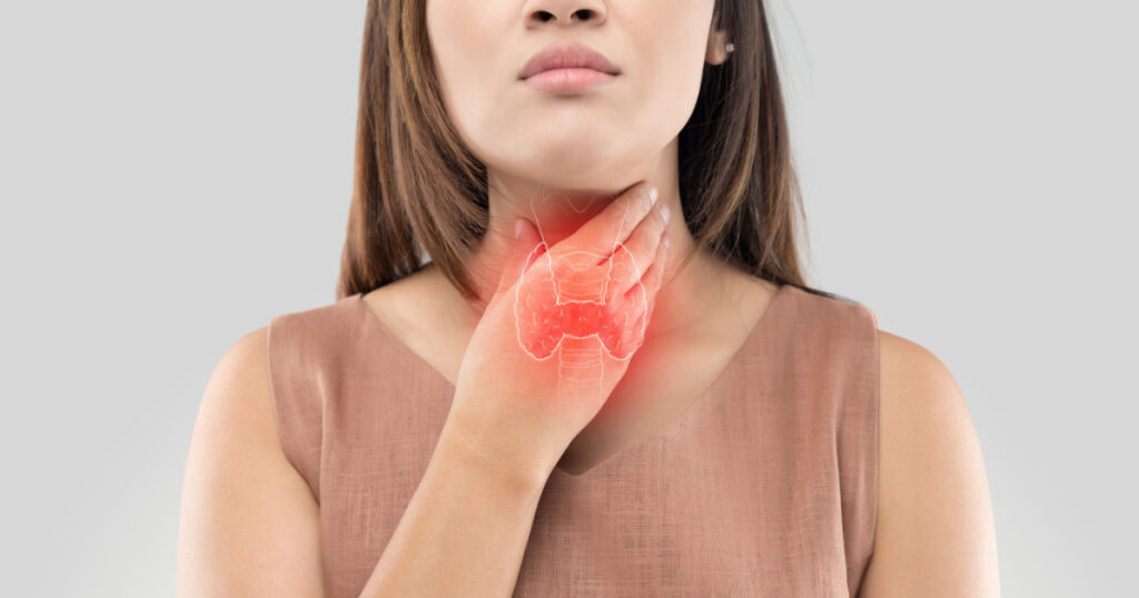 The photo of thyroid is on the human body, Women thyroid gland control. Sore throat of a people against gray background
