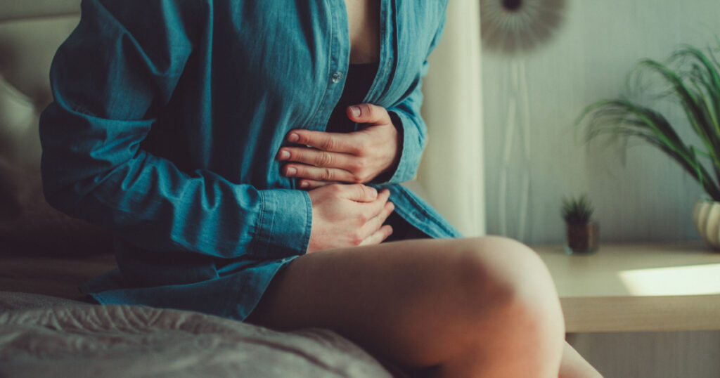 Woman having painful stomach ache. Female suffering from abdominal pain. Pain in the abdomen due to menstruation period and PMS. Inflammation in the body and infection, cystitis
