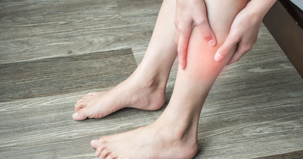 Closeup of woman hands holding and massaging her calf, suffering from calf pain. Calf pain may be muscle-related diagnoses, there are some potentially serious ones , like a blood clot or claudication.
